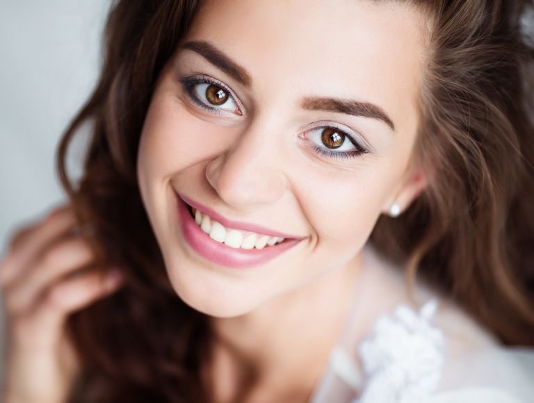 Portrait of smiling woman with perfect smile and white teeth looking at camera.